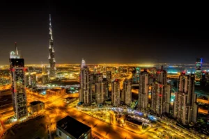 Aerial night view of Dubai skyline with the illuminated Burj Khalifa surrounded by skyscrapers and glowing city lights