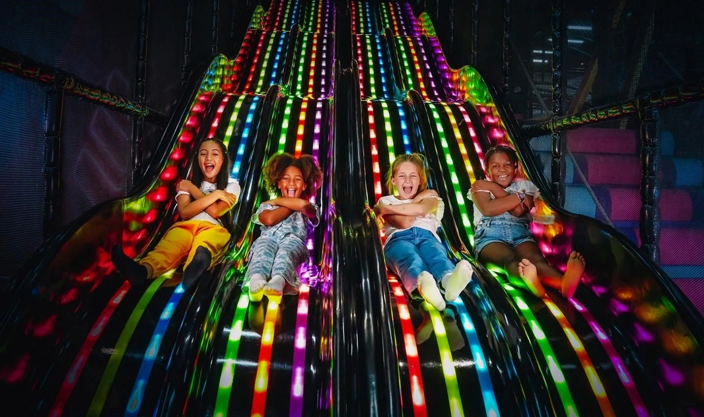 Children playing on vibrant trampolines at Bounce X indoor freestyle terrain park in Dubai