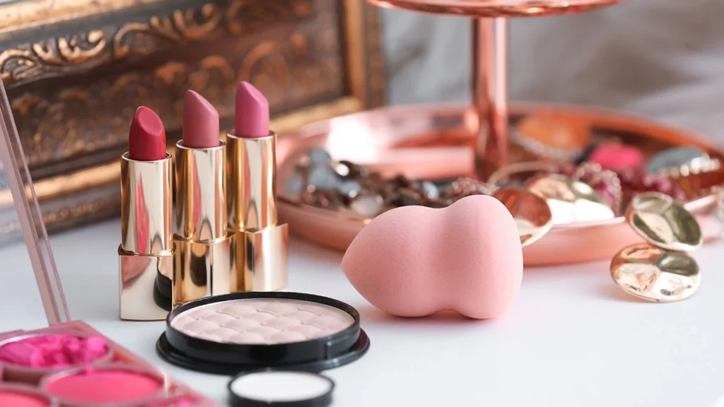 Assorted makeup tools and beauty products on white background.