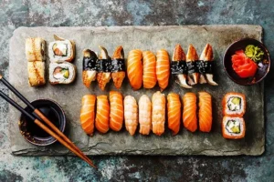 Diverse sushi platters with salmon, tuna, and shrimp nigiri filled with wasabi and pickled ginger.