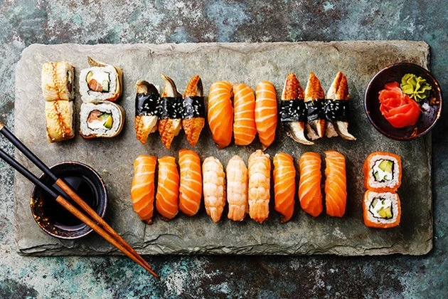 Diverse sushi platters with salmon, tuna, and shrimp nigiri filled with wasabi and pickled ginger.