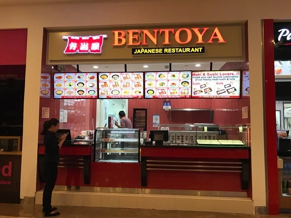 Chef crafting sushi behind the counter at Bentoya Kitchen