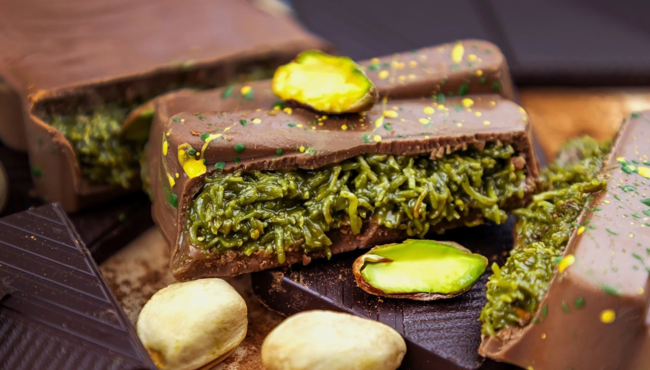 Premium chocolate bark packed with rich green pistachio mixture, topped with edible gold and pistachio bits.
