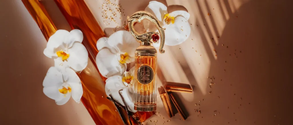 Lattafa perfume in beautiful glass bottles, featuring a golden, stylish cap with cinnamon and white flowers in the background.