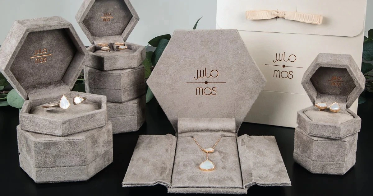 Mas Jewels rings, necklaces, and earrings are elegantly shown in signature hexagon suede boxes with engraved packaging.