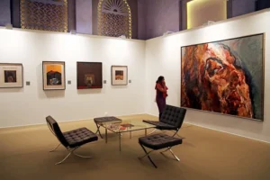 A visitor admires a piece of wall art hanging on the wall, accompanied by an aesthetically set table on the floor.