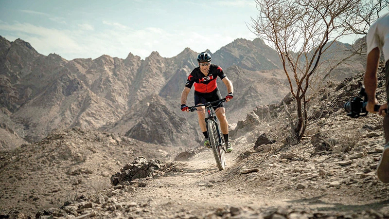 a mountain biker riding through mountains at Hatta.