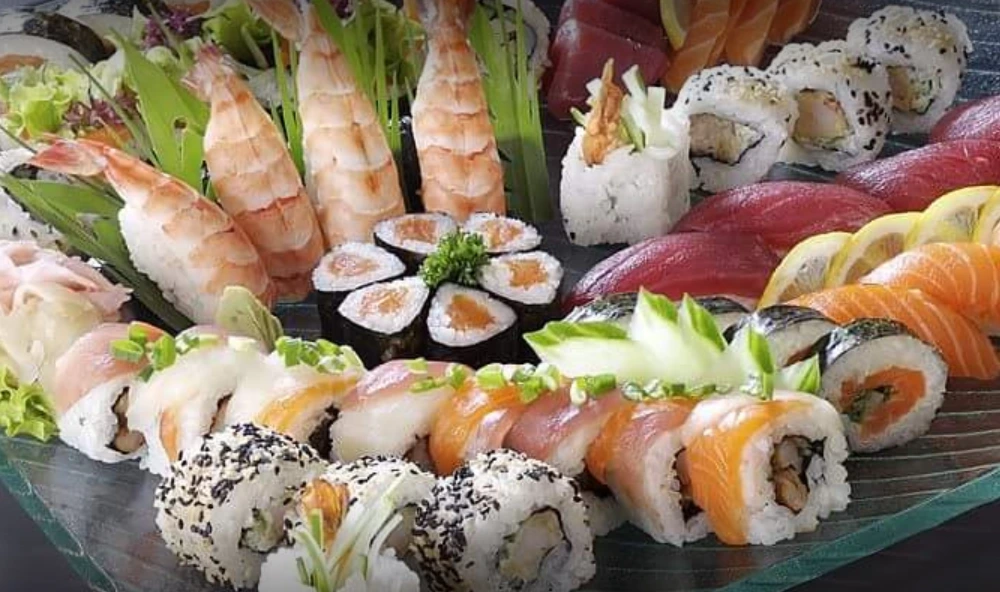 Rich mixed sushi platter with ebi nigiri, tuna sashimi rolls, salmon maki, and fresh garnishes at Bentoya Kitchen Dubai.
