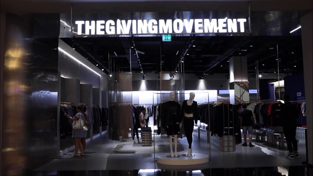 The Giving Moment Shop displays soft fabric dresses portrayed on mannequins, each dress featuring a modern style in neutral, vibrant colors.