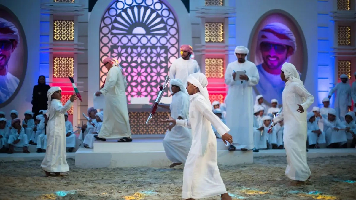 Emirati child performing the Yola dance on stage in front of the audience.