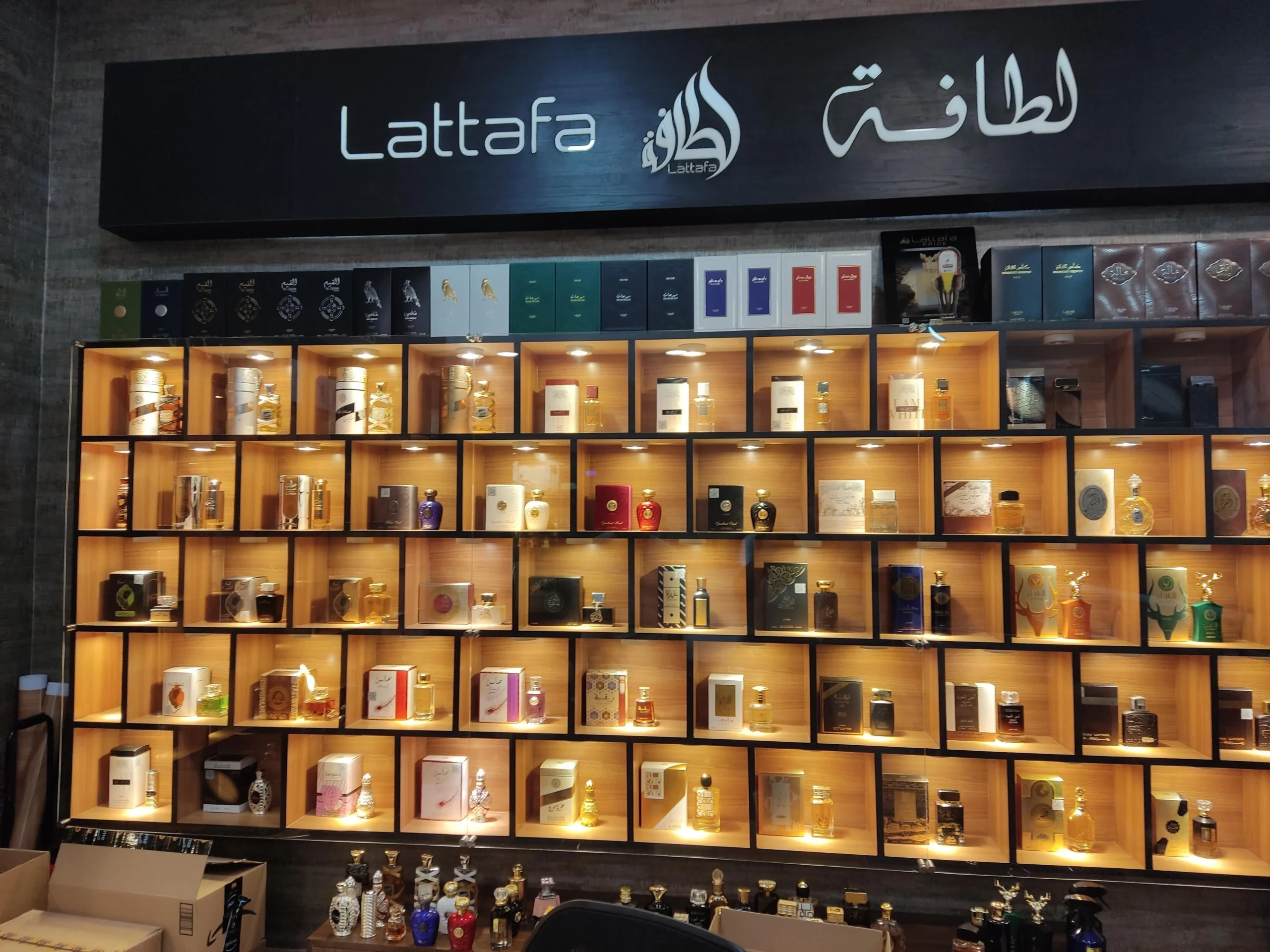 Lattafa perfumes are showcased in beautiful bottles and packaging within a wooden frame box.